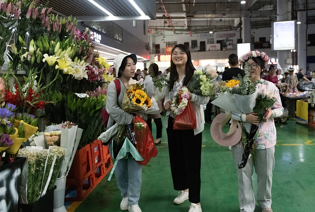 几名外地游客在昆明斗南花卉市场内购买鲜花（7月13日摄）。新华社记者 陈欣波 摄